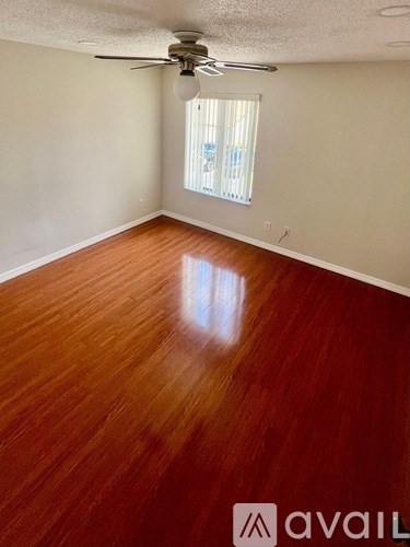 A room with wooden flooring and a ceiling fan.