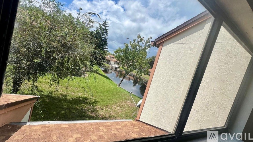 A view from a window looking out at a green lawn and trees.