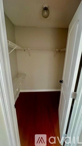 A white closet with a white door and a white hanger.