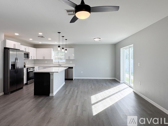 A living room with a couch, a coffee table, and a ceiling fan.