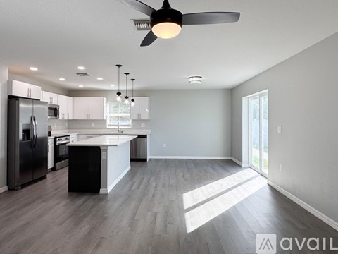 A living room with a couch, a coffee table, and a ceiling fan.