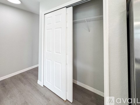 A white door is open in a room with a grey floor.