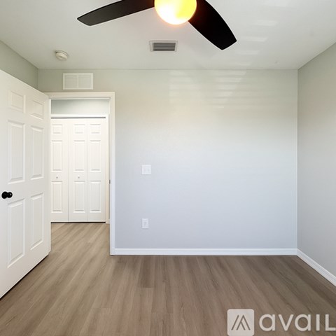 A room with a ceiling fan and a door.
