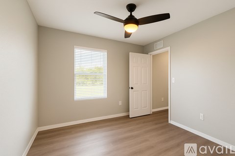 A room with a ceiling fan and a door.