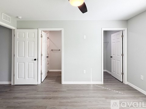 A room with two doors and a ceiling fan.