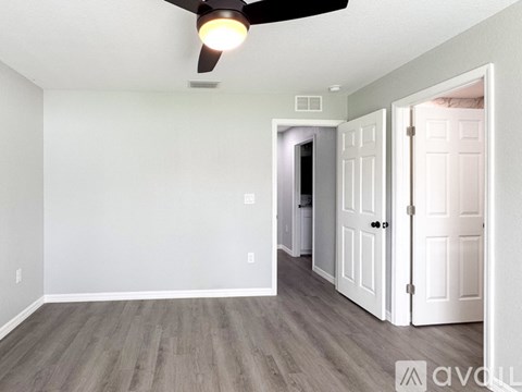 A room with a ceiling fan and a light on.