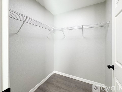 A white closet with a door and a shelf.