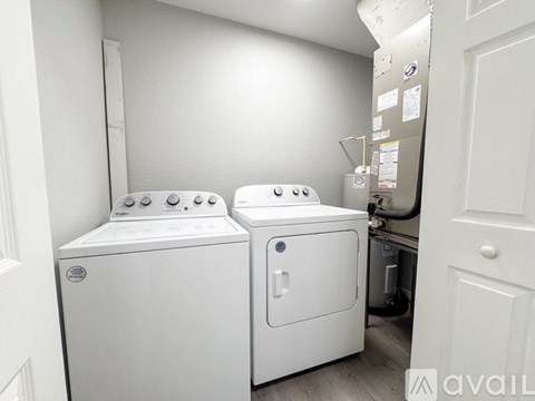 A white dryer and washer are in a small laundry room.