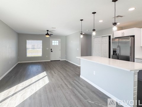 A modern kitchen with a large island and a dining area.