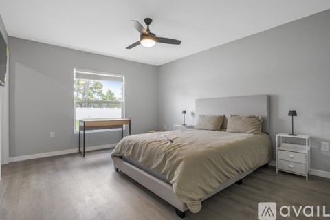 A bedroom with a bed, nightstand, and window.