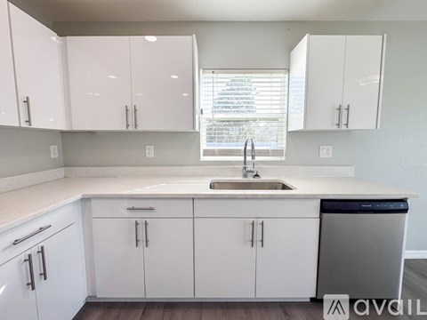 A kitchen with white cabinets and a sink.