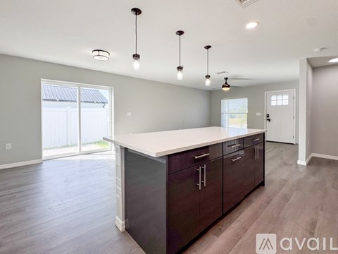 A kitchen with dark brown cabinets and a white countertop is available for rent.