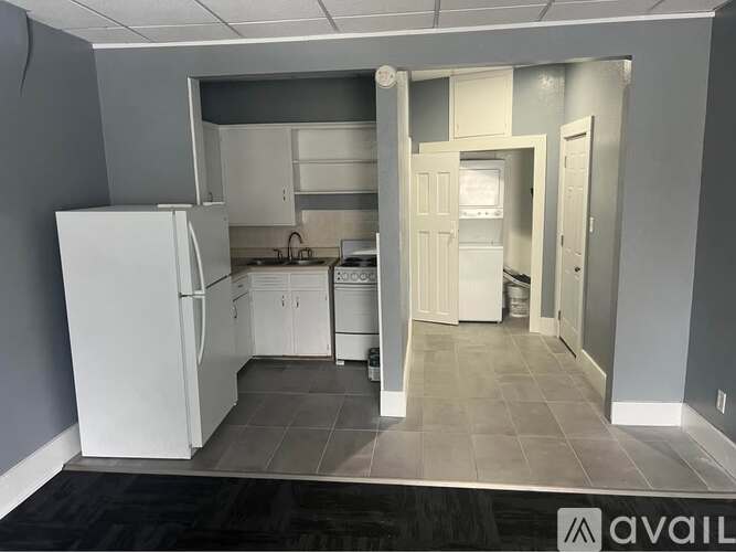A kitchen with white appliances and cabinets is available for rent.