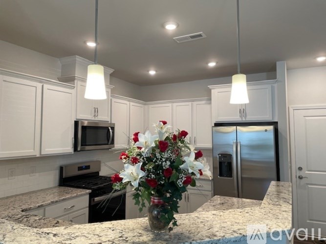 A kitchen with a granite countertop and a vase of flowers on it.