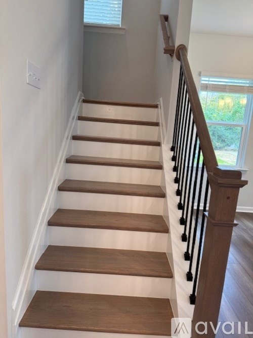 A staircase with wooden steps and a black railing.
