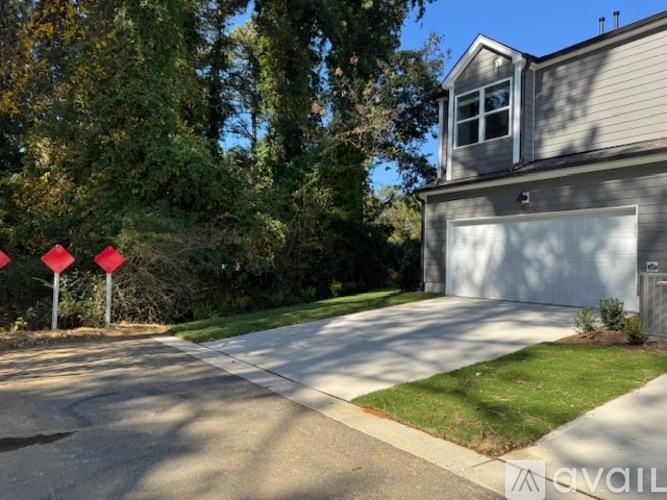 A house with a garage and a driveway with four red stop signs.