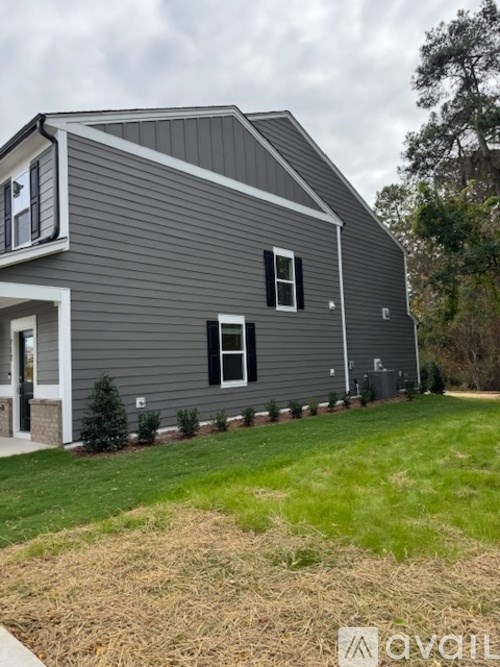 A grey house with a white door and windows.
