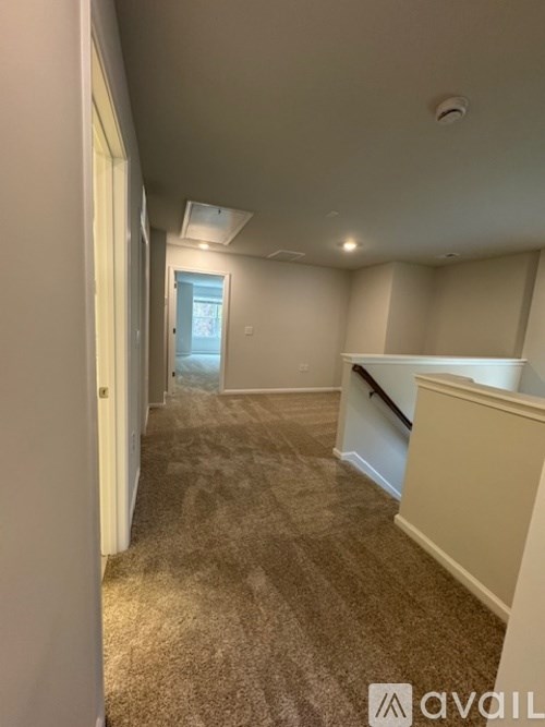 A carpeted hallway with a door at the end.