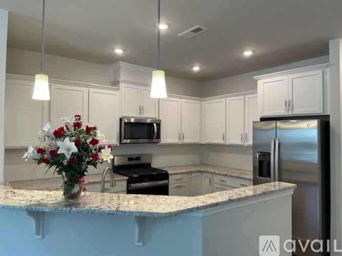 A kitchen with a granite countertop and stainless steel appliances.