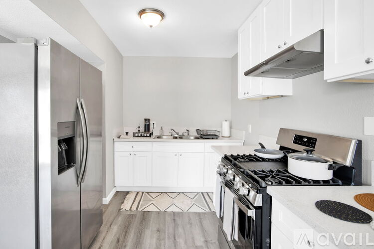 A modern kitchen with a stainless steel refrigerator and a stove top oven.