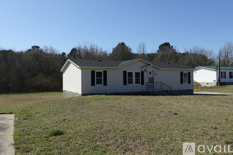A small house with a blue door and black shutters is for sale.