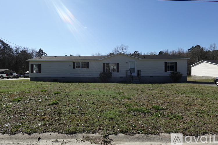 A house with a grey roof and a white door is for sale.