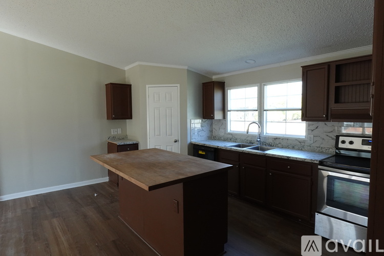 A kitchen with brown cabinets and a wooden island.