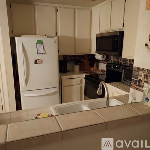 A kitchen with a white fridge and a black microwave.