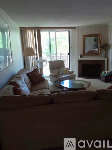 A living room with a couch, chair, and fireplace.