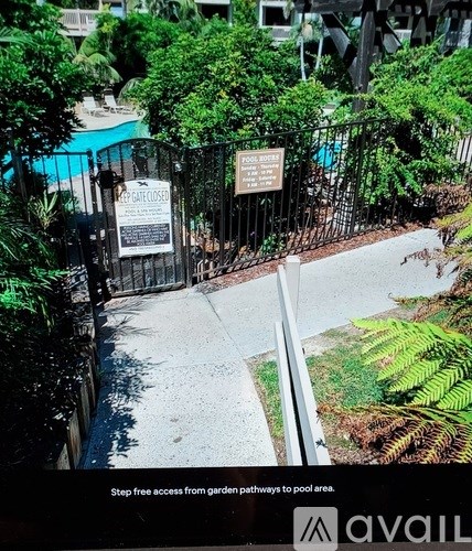 A pool area is surrounded by a fence and has a sign that says Leaf Guard Closed.