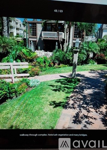 A walkway through a complex with bush vegetation and many bridges.