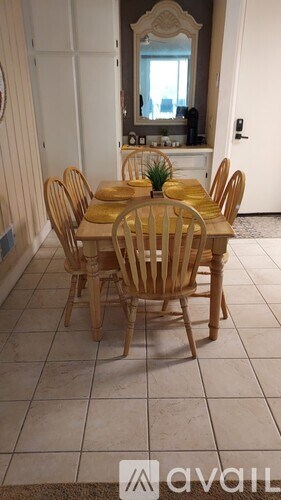 A wooden dining table with chairs in a room.