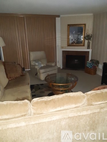 A living room with a fireplace and a painting on the wall.