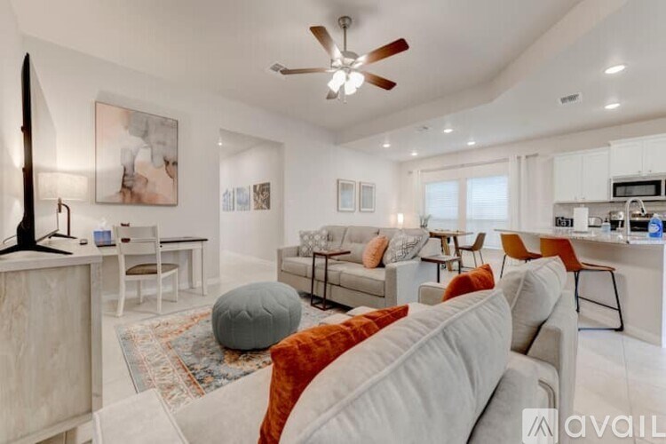 A living room with a grey couch and a rug.