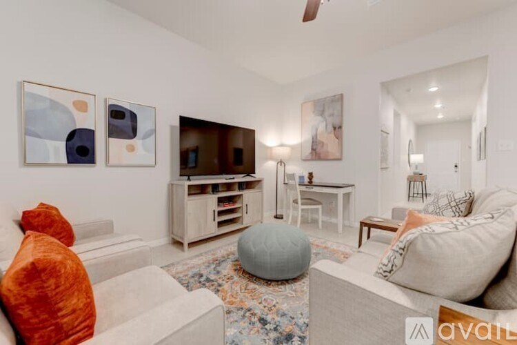 A living room with a couch, a chair, a coffee table, and a television.