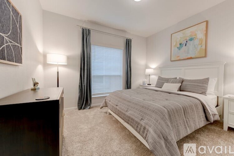 A bedroom with a bed, nightstand, and a painting on the wall.