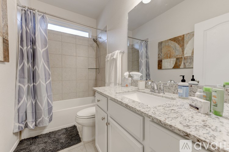 A bathroom with a toilet, sink, and shower.