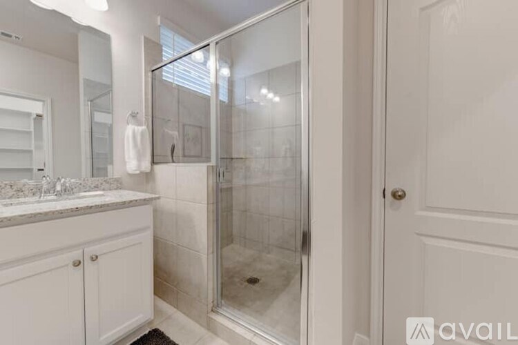 A bathroom with a walk-in shower and a white cabinet.