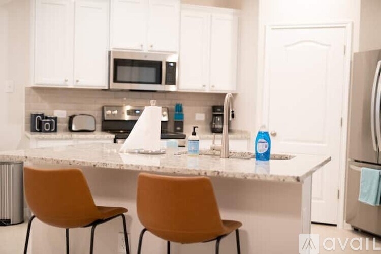 A kitchen with white cabinets and a marble countertop.