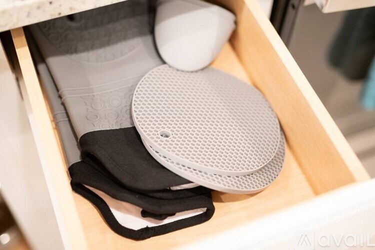 A white and black portable speaker is placed in a drawer.