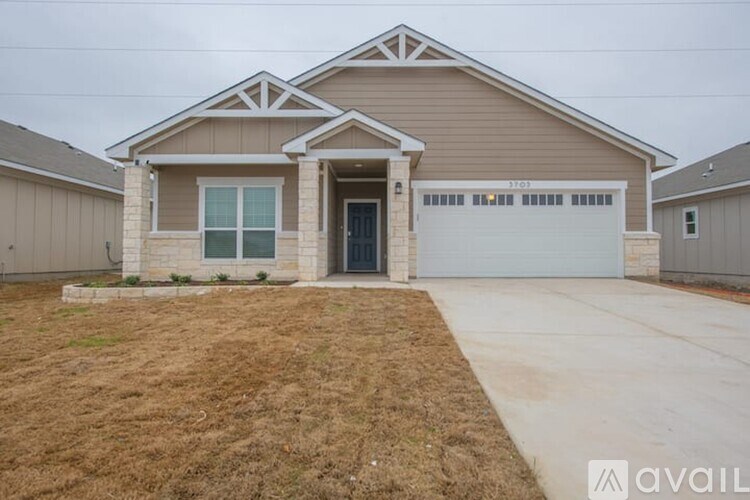 A house with a garage and a driveway in front.