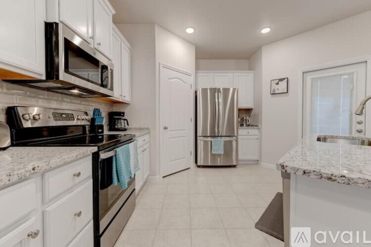 A kitchen with white cabinets and a granite countertop.