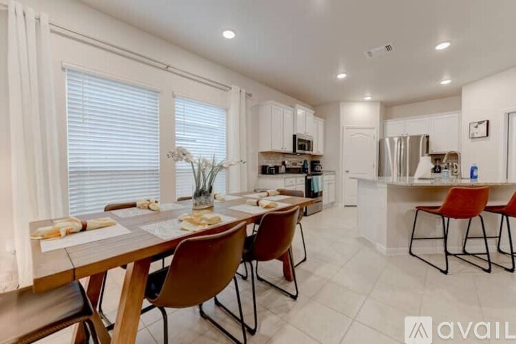 A modern kitchen with a dining table set for two.