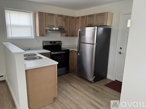 A kitchen with a refrigerator, sink, and stove.