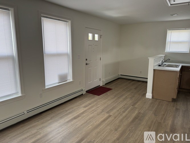 A room with a door, windows, and a desk.