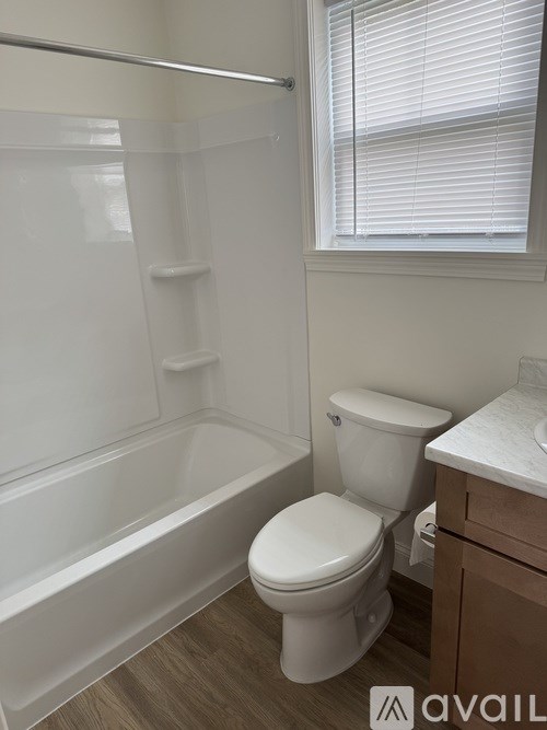 A white toilet sits next to a bathtub in a bathroom.