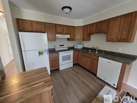 A kitchen with wooden cabinets and a white fridge.