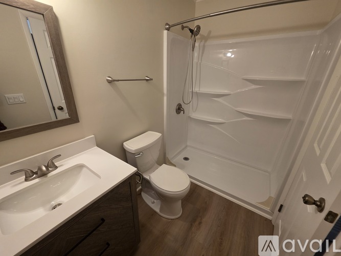 A bathroom with a toilet, sink, and shower.