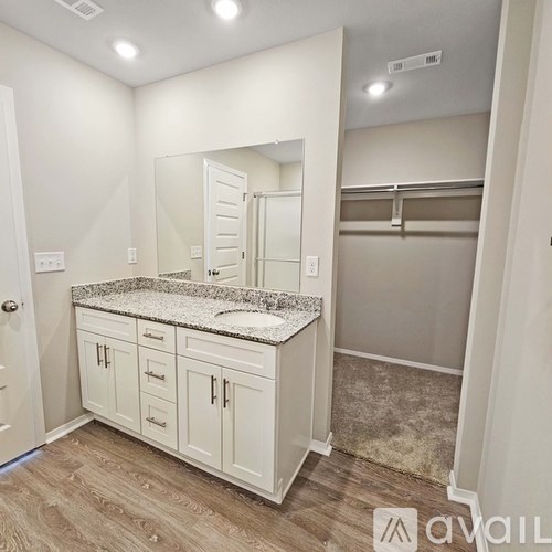 A kitchen with white cabinets and a granite countertop.