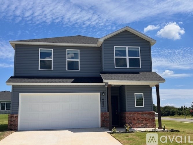 A two-story house with a garage is available for sale.